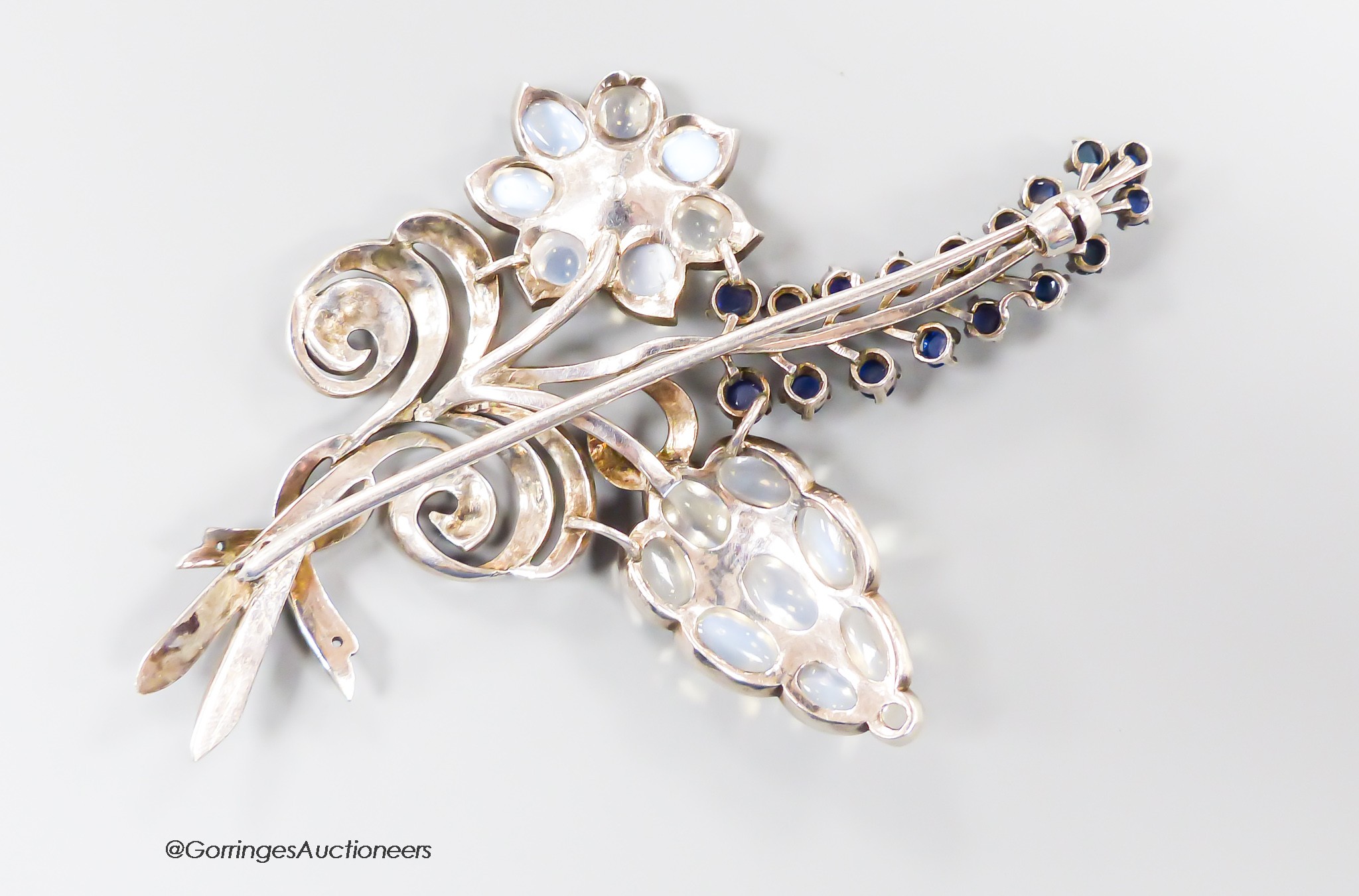 A white metal, moonstone and cabochon blue quartz? cluster set floral spray brooch, 91mm, gross weight 28.6 grams.